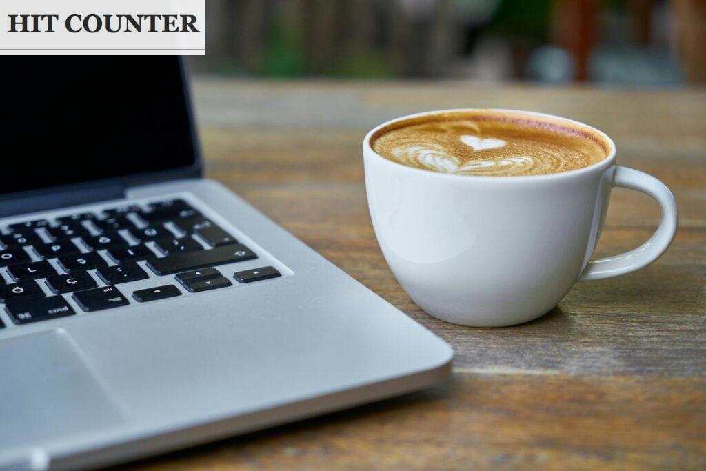 Teacup of Latte Beside Macbook Pro