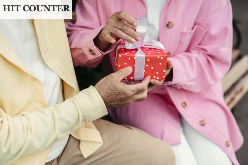 Man in Pink Dress Shirt Holding Red and White Polka Dot Container