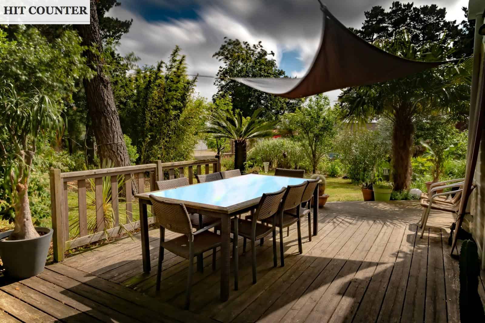 brown wooden table with chairs and umbrella