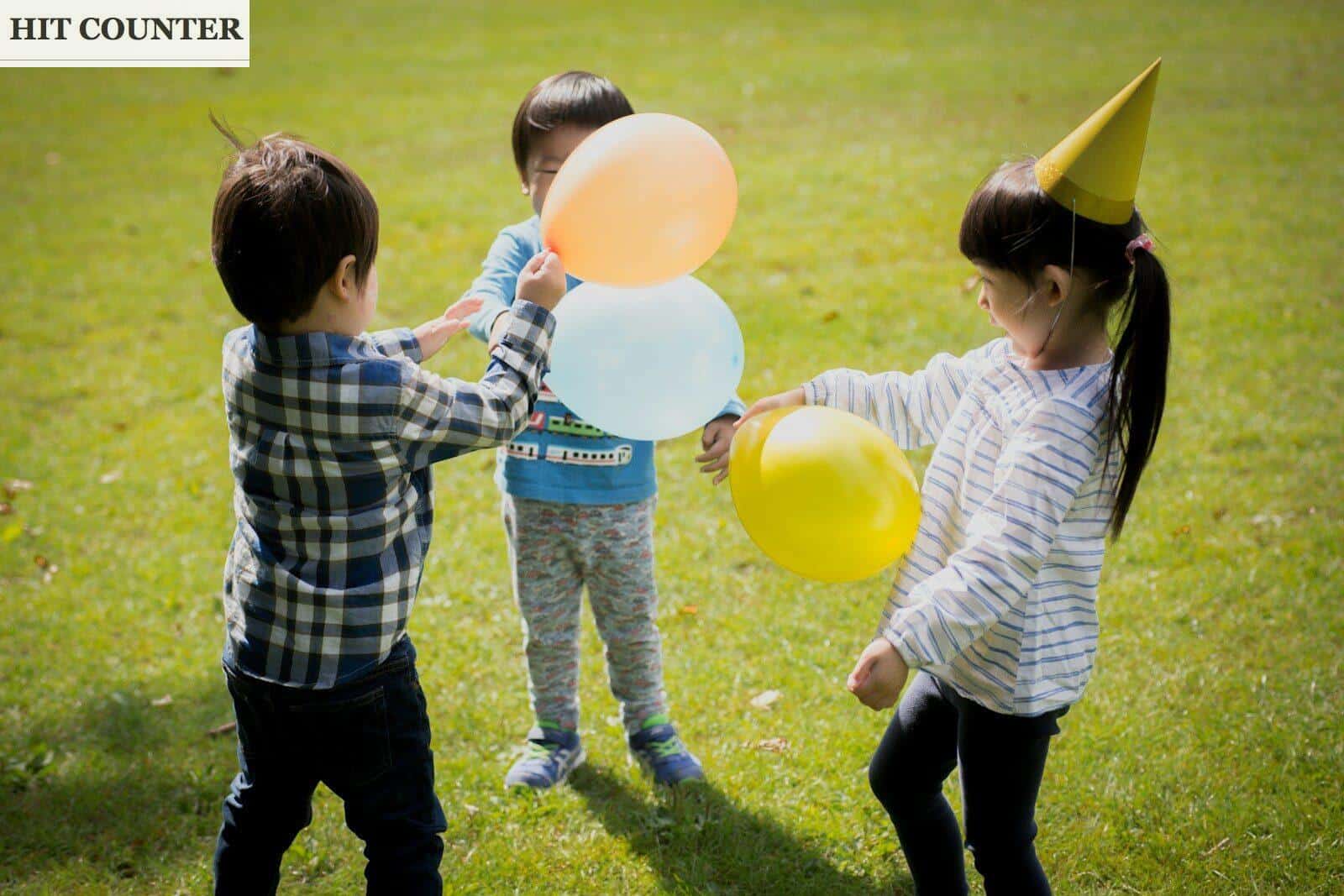 boy in blue and white plaid dress shirt holding yellow balloons