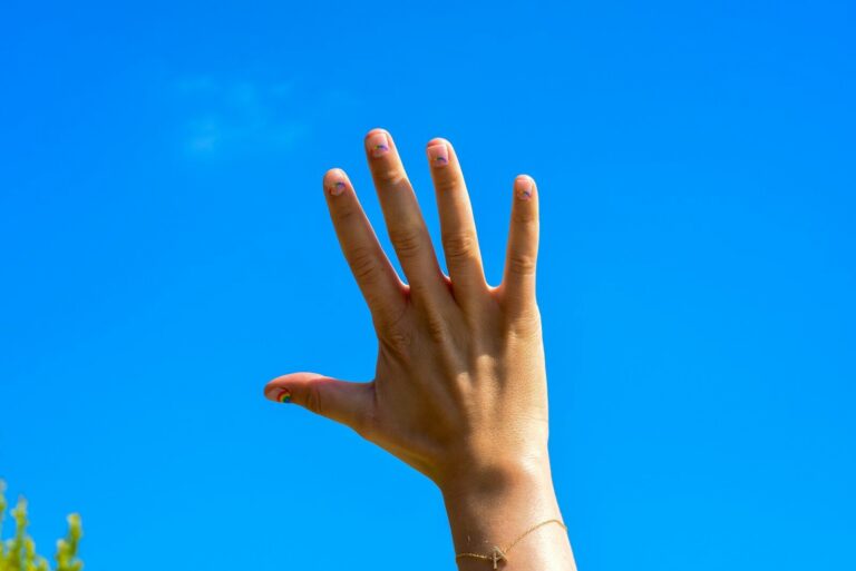 Mano levantada contra el cielo azul para hacer una pregunta a la redacción